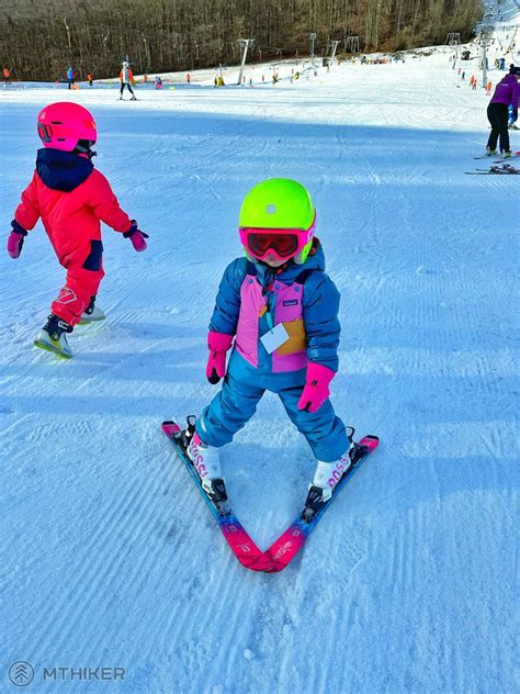 Deti si užívajú lyžovanie na zasneženom svahu.