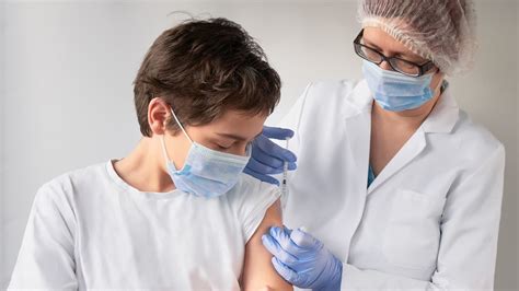 Lekár vyšetrujúci dieťa pred očkovaním