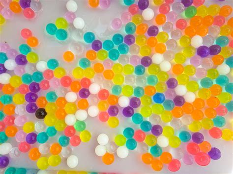 Dieťa prelieva farebné vodné perly