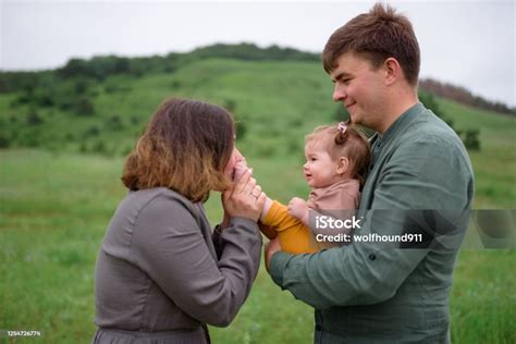 Symbolická fotografia rodičov držiacich v náručí malé bábätko