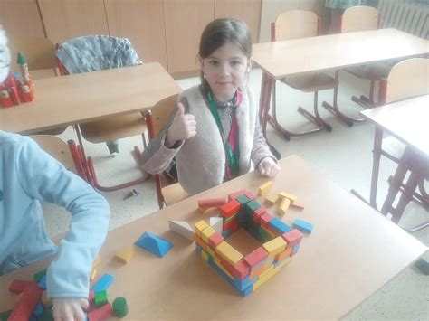 Rodičia pomáhajú dieťaťu stavať vežu z kociek