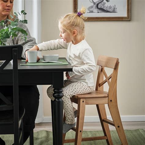 Dieťa sediace pri jedálenskom stole a jesť