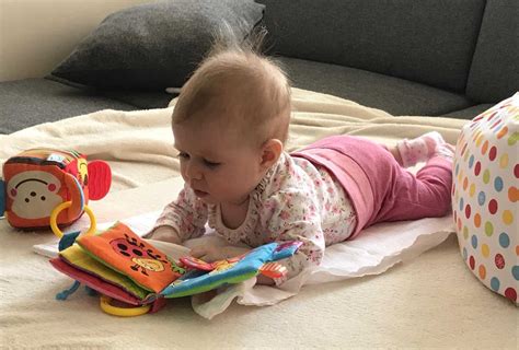 dieťa sa naťahuje za hračkou v polohe na brušku