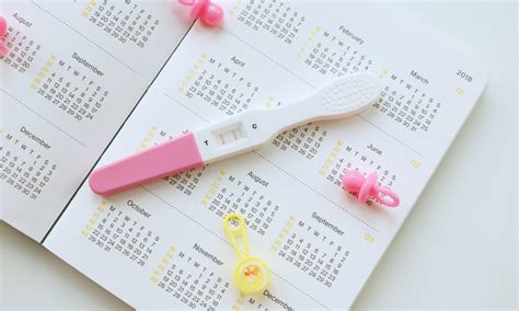 Žena porovnávajúca kalendár a tehotenský test