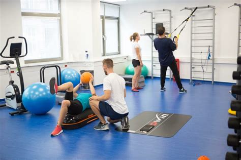 Skupina ľudí cvičiacich s fitloptami v štúdiu