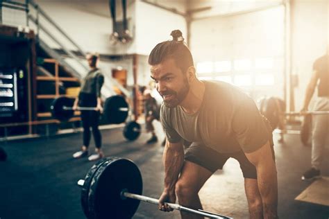 Človek cvičiaci s činkami v posilňovni