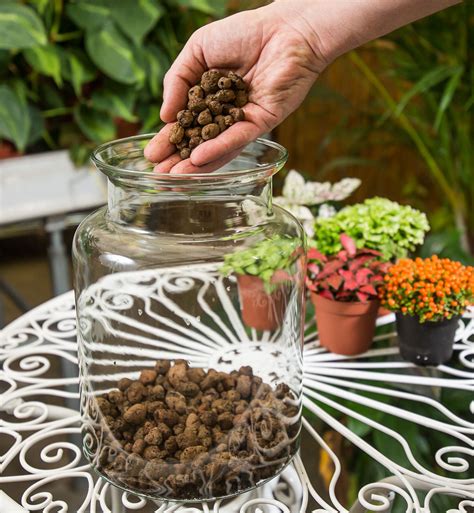 dieťa vhadzuje gombíky do sklenenej nádoby