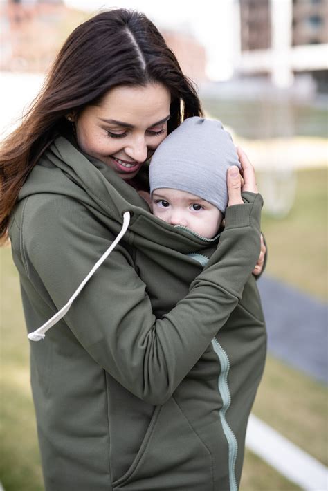 Žena dojčiaca dieťa v nosiacej mikine